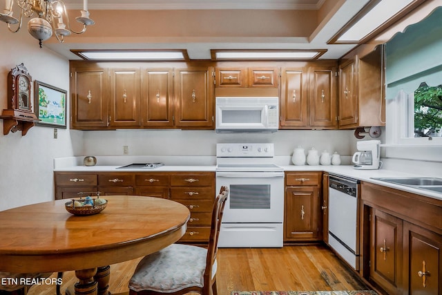 105 N Church St, Sparta, TN 38583 - kitchen with white appliances, light countertops, light wood-type flooring, a chandelier, and brown cabinetry