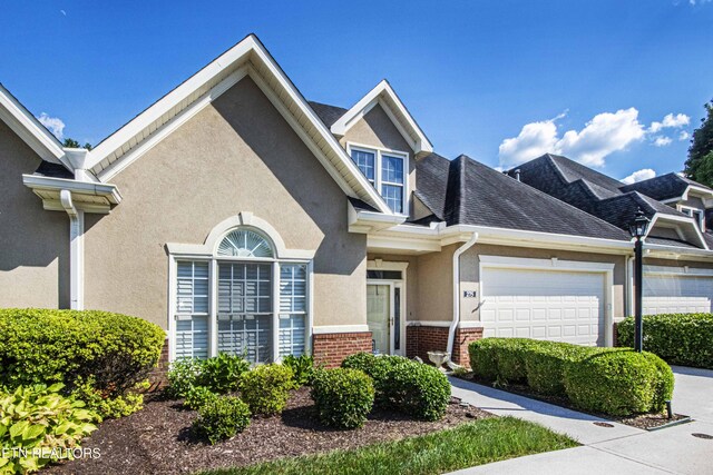275 Fordham Way, Knoxville, TN 37934 - townhome / multi-family property featuring brick siding, a garage, stucco siding, and driveway