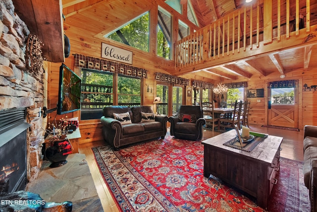 4410 Forest Vista Way, Pigeon Forge, TN 37863 - living room with wood walls, a wooden ceiling with exposed beams, wood finished floors, a stone fireplace, and high vaulted ceiling