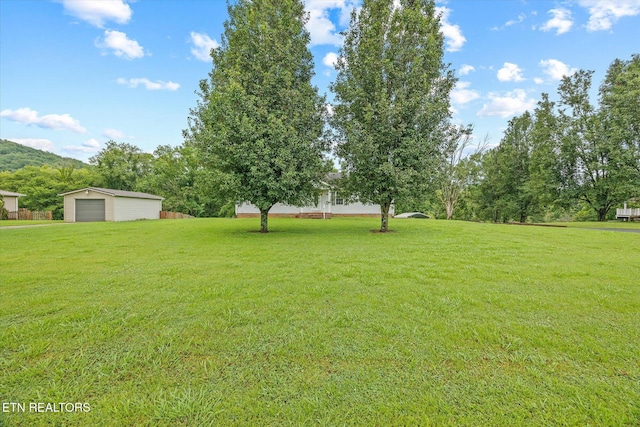 454 Boyd St, Celina, TN 38551 - view of grassy yard featuring a detached garage and an outbuilding