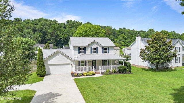 348 Ridge Rd, Caryville, TN 37714 - view of front of house with a porch, a garage, a front lawn, driveway, and a metal roof