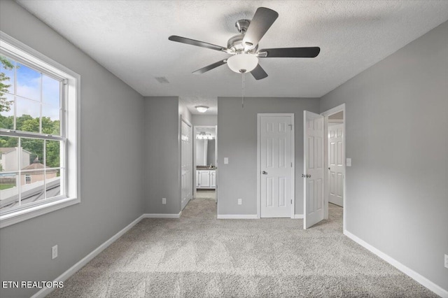 348 Ridge Rd, Caryville, TN 37714 - unfurnished bedroom with carpet, a textured ceiling, connected bathroom, and a ceiling fan