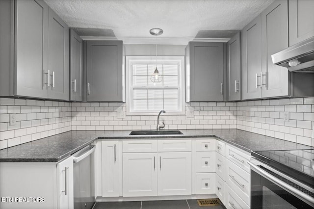 348 Ridge Rd, Caryville, TN 37714 - kitchen with stainless steel dishwasher, gray cabinetry, under cabinet range hood, range, and a textured ceiling
