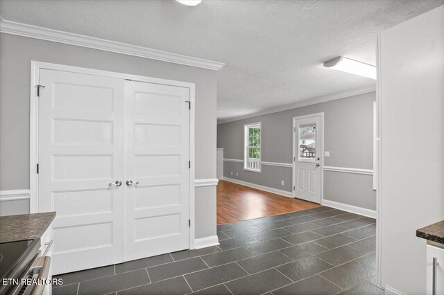 348 Ridge Rd, Caryville, TN 37714 - foyer entrance with a textured ceiling, ornamental molding, and dark tile patterned flooring