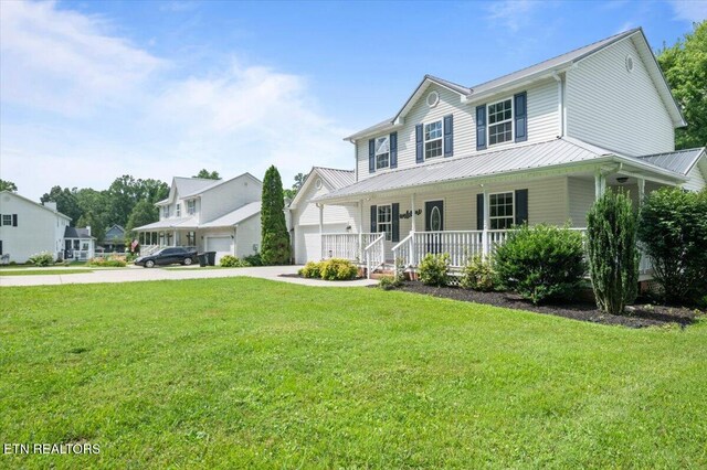 348 Ridge Rd, Caryville, TN 37714 - view of front of property with covered porch, a front lawn, concrete driveway, and a metal roof