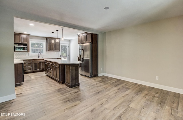516 Golden Harvest Rd, Knoxville, TN 37934 - kitchen with stainless steel appliances, light countertops, backsplash, light wood-style floors, and dark brown cabinets