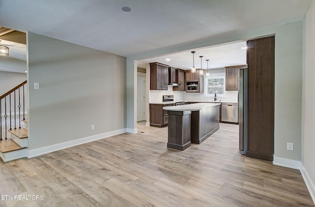 516 Golden Harvest Rd, Knoxville, TN 37934 - kitchen featuring appliances with stainless steel finishes, dark brown cabinets, a kitchen island, light wood finished floors, and light countertops