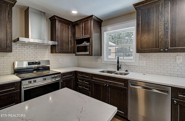 516 Golden Harvest Rd, Knoxville, TN 37934 - kitchen featuring stainless steel appliances, wall chimney range hood, dark brown cabinetry, tasteful backsplash, and light stone counters