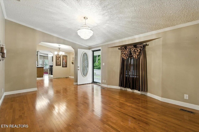 2953 US Highway 119, Pineville, KY 40977 - empty room featuring a chandelier, hardwood / wood-style flooring, a textured ceiling, arched walkways, and crown molding