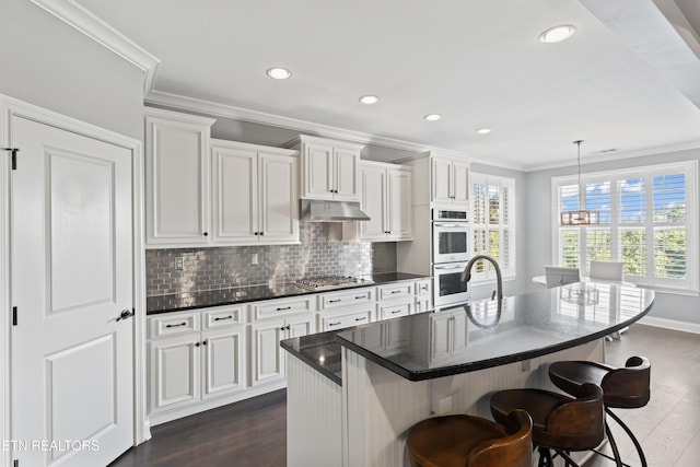 1273 Bishops View Ln, Knoxville, TN 37932 - kitchen featuring stainless steel appliances, ornamental molding, a kitchen bar, decorative backsplash, and dark wood-style flooring