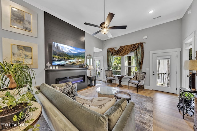 2570 NE Spring Creek Dr, Cleveland, TN 37311 - living area with wood finished floors, a glass covered fireplace, ceiling fan, a towering ceiling, and recessed lighting