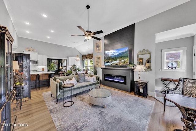2570 NE Spring Creek Dr, Cleveland, TN 37311 - living area with light wood-style flooring, recessed lighting, a glass covered fireplace, ceiling fan, and vaulted ceiling