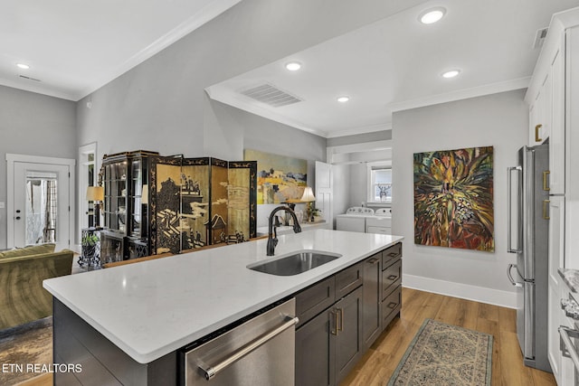 2570 NE Spring Creek Dr, Cleveland, TN 37311 - kitchen featuring appliances with stainless steel finishes, independent washer and dryer, open floor plan, crown molding, and light countertops