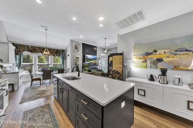 2570 NE Spring Creek Dr, Cleveland, TN 37311 - kitchen with light countertops, white cabinetry, light wood-type flooring, a kitchen island with sink, and ceiling fan