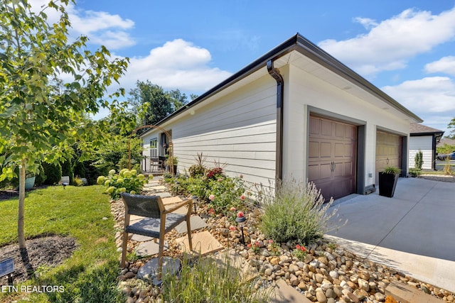 2570 NE Spring Creek Dr, Cleveland, TN 37311 - view of side of property featuring a garage, driveway, and a lawn