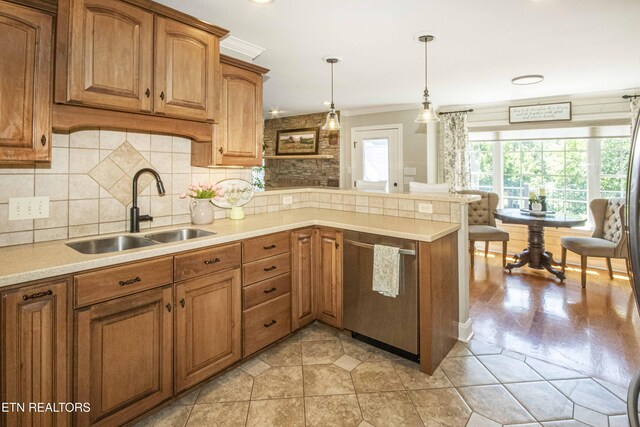 9436 Naff Rd, Heiskell, TN 37754 - kitchen featuring stainless steel dishwasher, brown cabinetry, light countertops, ornamental molding, and a peninsula
