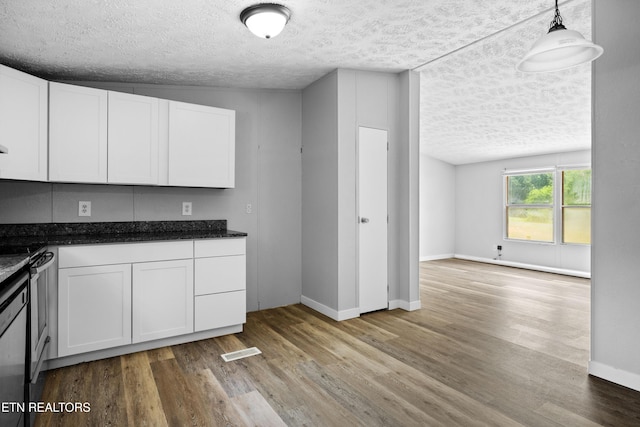 1768 Fain Cemetery Rd, Dandridge, TN 37725 - kitchen with a textured ceiling, light wood-style flooring, white cabinetry, stainless steel range with gas stovetop, and dark stone countertops