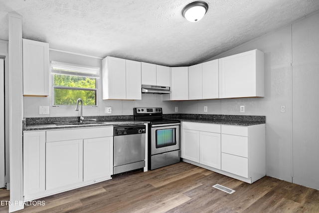 1768 Fain Cemetery Rd, Dandridge, TN 37725 - kitchen featuring stainless steel appliances, under cabinet range hood, a textured ceiling, wood finished floors, and white cabinets