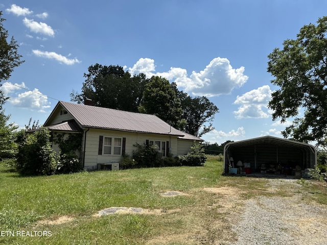 1890 Doaks Creek Rd, Speedwell, TN 37870 - view of front of house with a carport, dirt driveway, a front yard, and a metal roof