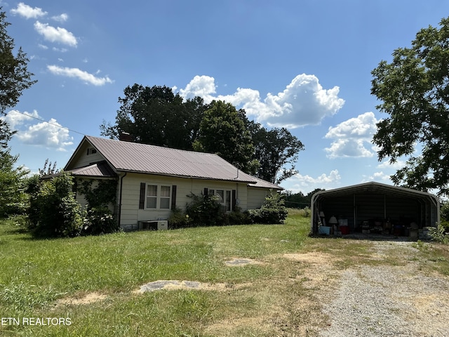 1890 Doaks Creek Rd, Speedwell, TN 37870 - view of home's exterior featuring a detached carport, dirt driveway, a lawn, and a metal roof