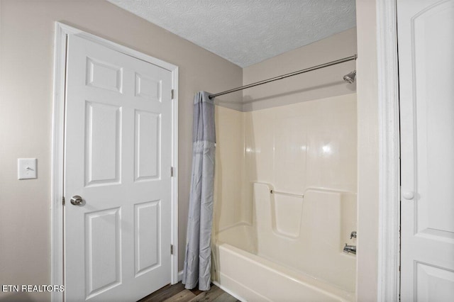 2270 Cove Pointe Rd, Lafollette, TN 37766 - full bath featuring shower / bathtub combination with curtain, a textured ceiling, and wood finished floors