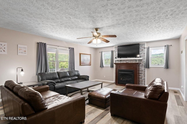 2270 Cove Pointe Rd, Lafollette, TN 37766 - living area with plenty of natural light, light wood-type flooring, ceiling fan, a brick fireplace, and a textured ceiling