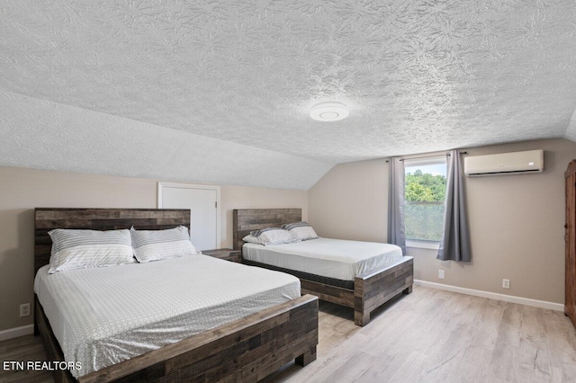 2270 Cove Pointe Rd, Lafollette, TN 37766 - bedroom featuring a wall mounted AC, light wood-style flooring, a textured ceiling, and vaulted ceiling