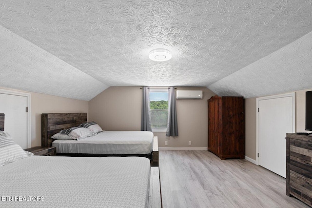 2270 Cove Pointe Rd, Lafollette, TN 37766 - bedroom featuring light wood finished floors, an AC wall unit, a textured ceiling, and lofted ceiling