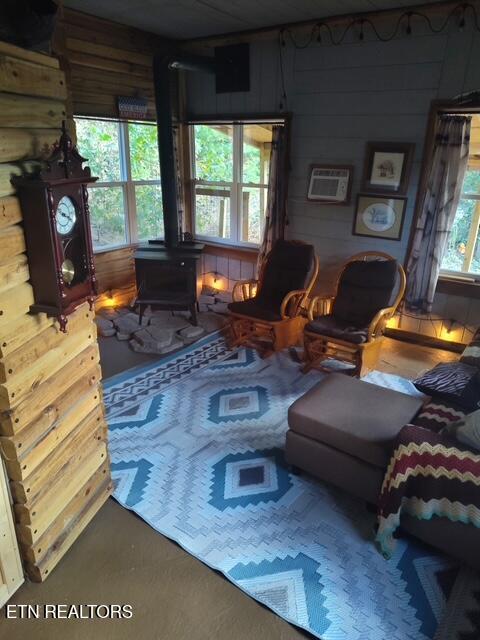 419 River Rd, Huntsville, TN 37756 - living area featuring a wood stove, wood walls, and a wall mounted air conditioner