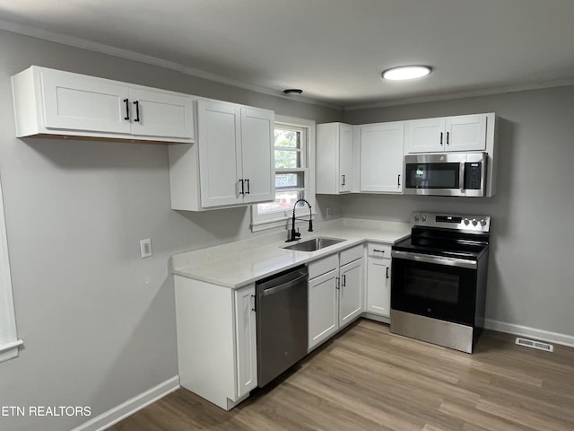 3431 Skyline Dr, Knoxville, TN 37914 - kitchen featuring stainless steel appliances, white cabinetry, light countertops, and crown molding