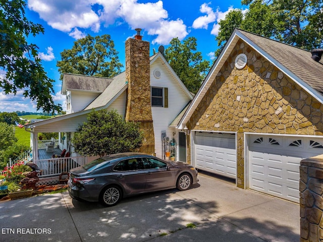 133 Rolling Hls, Rutledge, TN 37861 - view of front of home with concrete driveway, stone siding, a garage, and a chimney