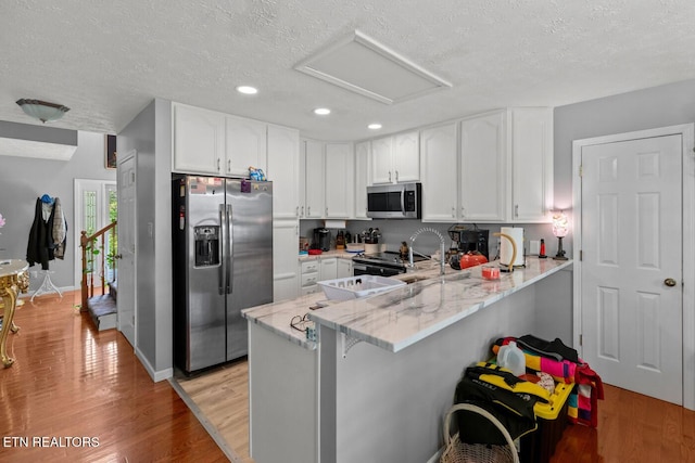 133 Rolling Hls, Rutledge, TN 37861 - kitchen featuring stainless steel appliances, a peninsula, a textured ceiling, recessed lighting, and white cabinetry