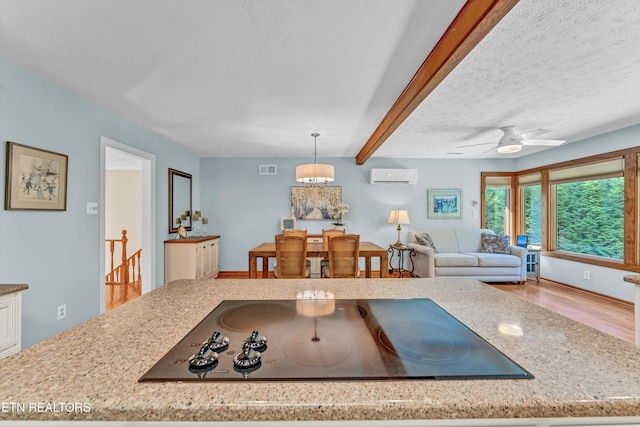 127 Newhaven Rd, Oak Ridge, TN 37830 - kitchen featuring a wall mounted air conditioner, black electric cooktop, wood finished floors, light stone countertops, and pendant lighting