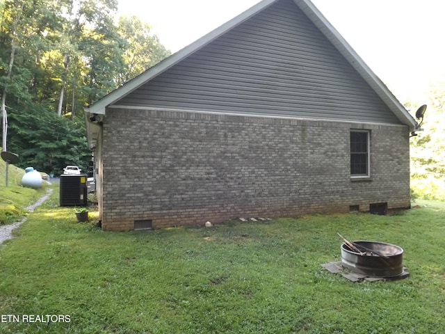 440 Sams Mtn, Middlesboro, KY 40965 - view of home's exterior featuring crawl space, an outdoor fire pit, a yard, and brick siding