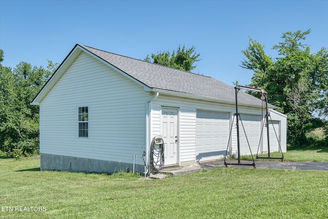 1036 Circle Dr, Jamestown, TN 38556 - view of home's exterior with an outbuilding, a detached garage, a lawn, and roof with shingles