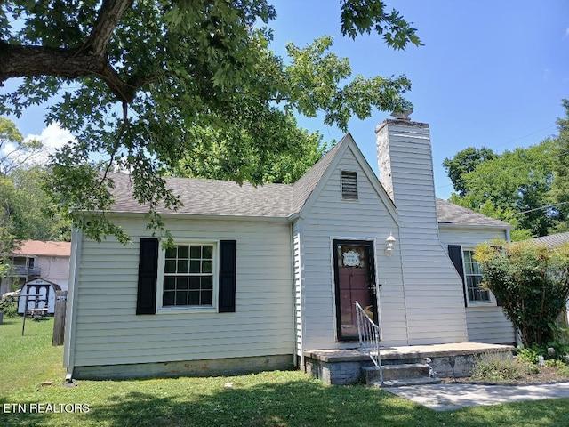 955 Poplar St, Alcoa, TN 37701 - bungalow featuring a front yard, a chimney, and roof with shingles