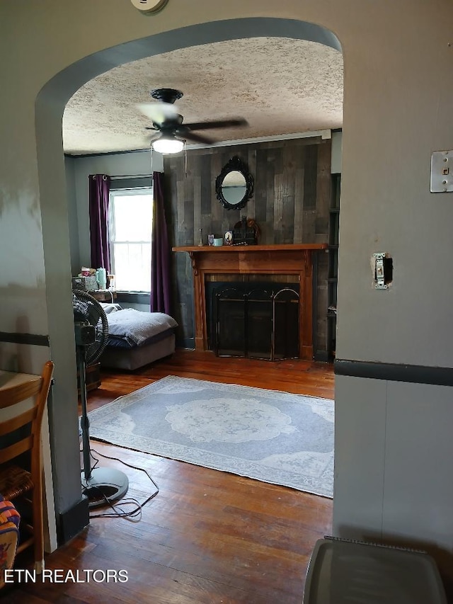 955 Poplar St, Alcoa, TN 37701 - living area with arched walkways, a textured ceiling, a fireplace, ceiling fan, and wood finished floors