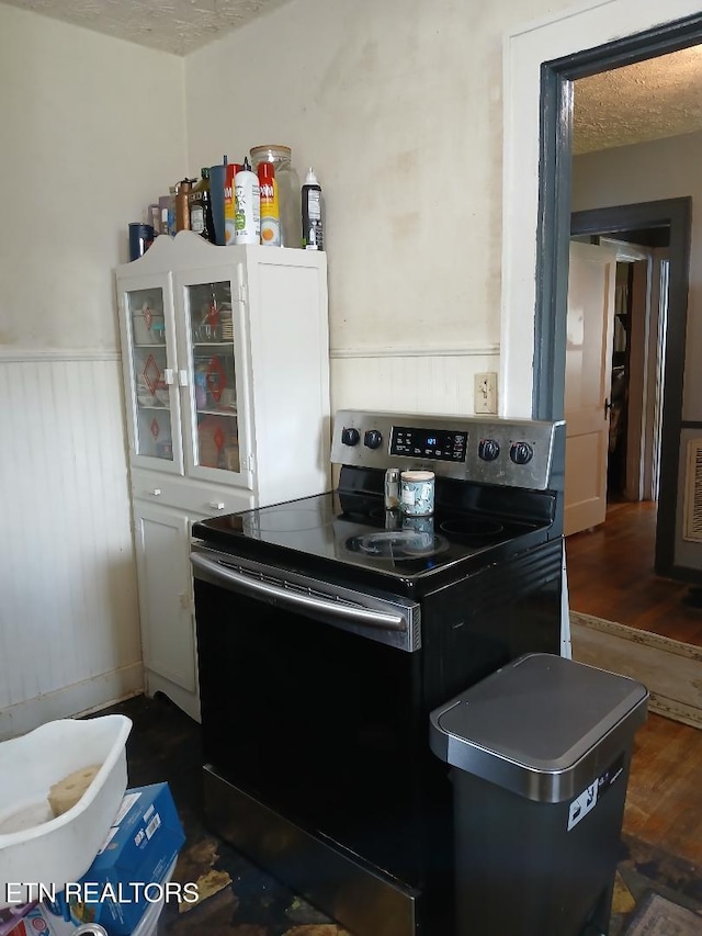955 Poplar St, Alcoa, TN 37701 - kitchen with stainless steel range with electric stovetop, wainscoting, glass insert cabinets, dark wood finished floors, and white cabinets