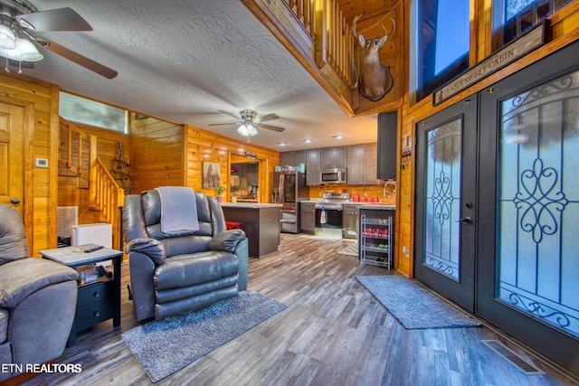 224 Eagle Blf, Jamestown, TN 38556 - living area with ceiling fan, wine cooler, stairway, light wood-type flooring, and wood walls
