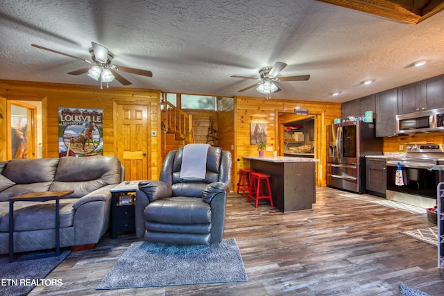 224 Eagle Blf, Jamestown, TN 38556 - living room featuring a ceiling fan, stairs, wood walls, wood finished floors, and a textured ceiling