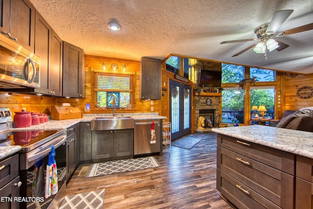 224 Eagle Blf, Jamestown, TN 38556 - kitchen featuring appliances with stainless steel finishes, wooden walls, a textured ceiling, open floor plan, and wood finished floors