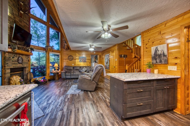 224 Eagle Blf, Jamestown, TN 38556 - living room featuring a textured ceiling, wood walls, stairway, a ceiling fan, and dark wood-style floors