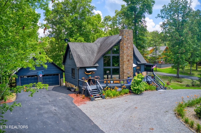 224 Eagle Blf, Jamestown, TN 38556 - view of front facade featuring a garage, an outbuilding, roof with shingles, a chimney, and a deck