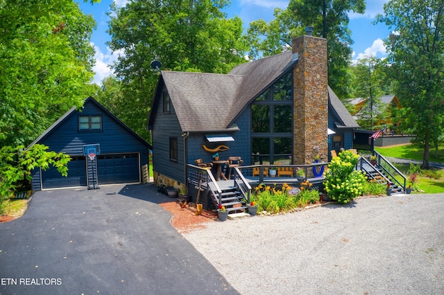 224 Eagle Blf, Jamestown, TN 38556 - view of front of house featuring a garage, an outdoor structure, roof with shingles, a chimney, and a wooden deck