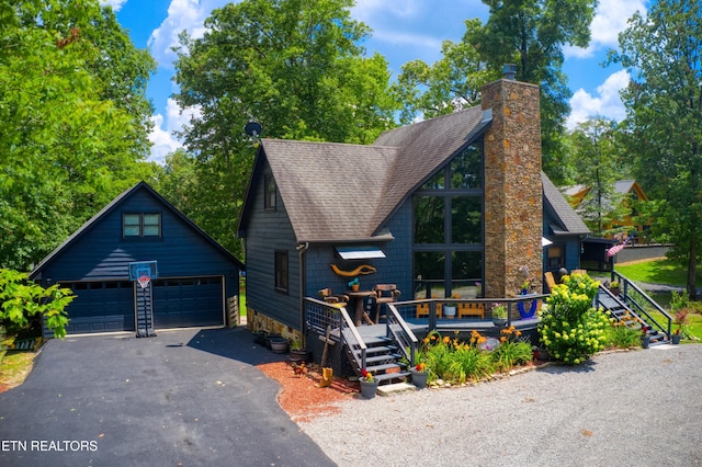 224 Eagle Blf, Jamestown, TN 38556 - view of front facade featuring a detached garage, roof with shingles, an outdoor structure, a chimney, and a wooden deck