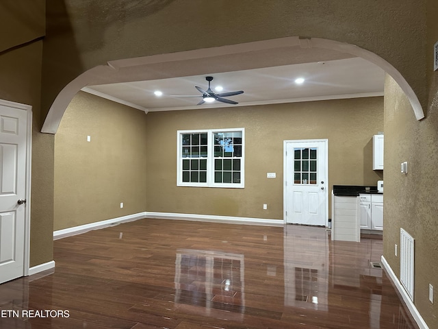 901 Kyle St, Lafollette, TN 37766 - unfurnished living room with arched walkways, crown molding, a textured wall, a ceiling fan, and wood finished floors