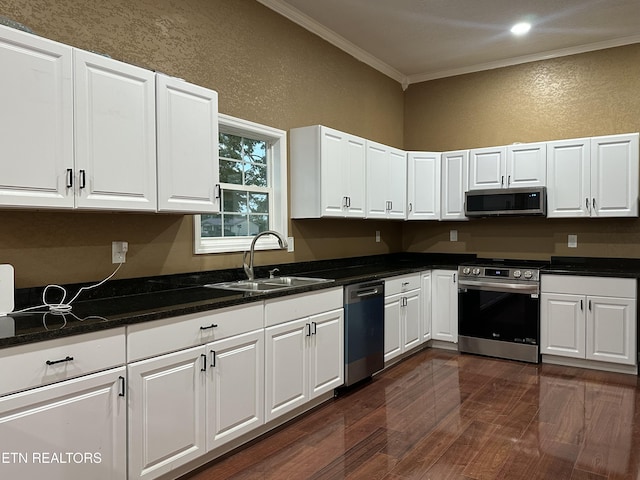 901 Kyle St, Lafollette, TN 37766 - kitchen featuring appliances with stainless steel finishes, ornamental molding, a textured wall, dark wood-style flooring, and white cabinets