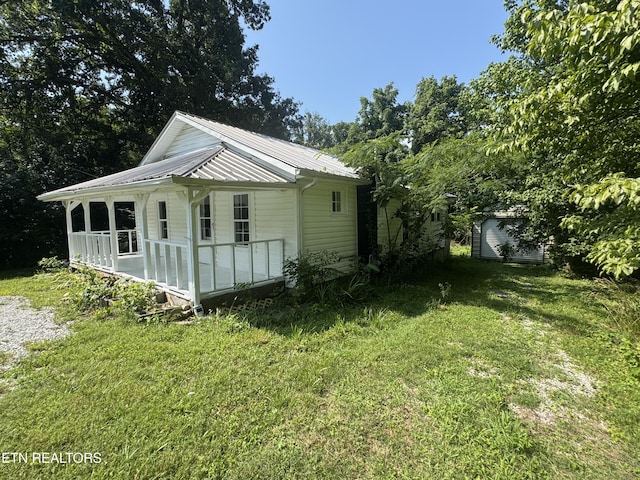 914 S 13th St, Lafollette, TN 37766 - view of front of house with a front yard, a shed, and a metal roof