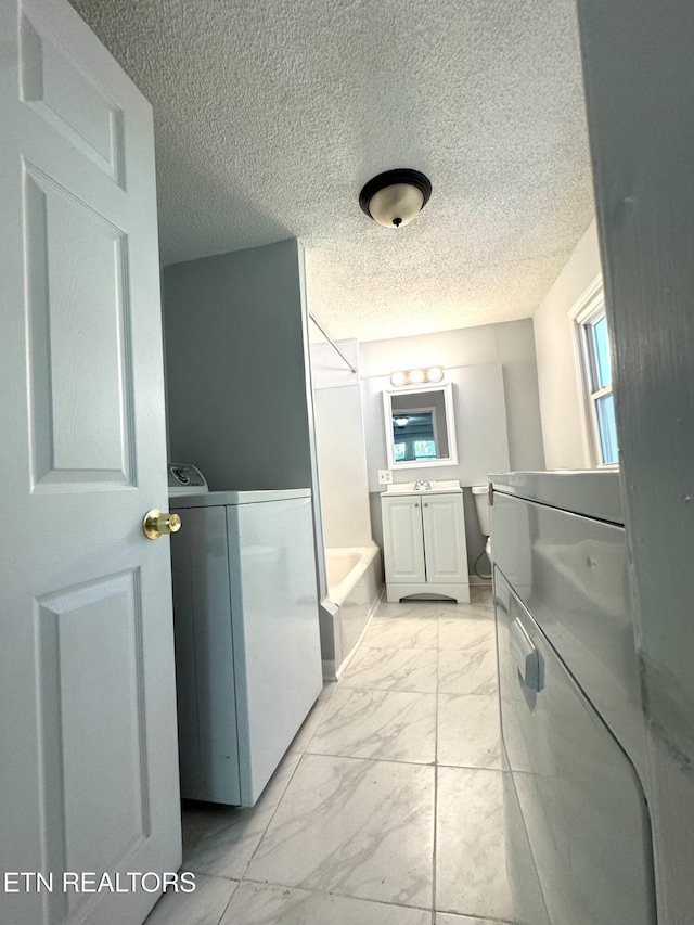 914 S 13th St, Lafollette, TN 37766 - full bathroom with vanity, marble look tiles, a textured ceiling, and washer / clothes dryer