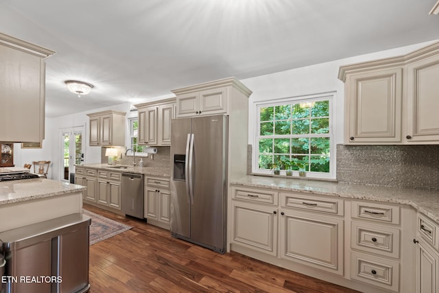 1521 Aldenwood Ln, Knoxville, TN 37919 - kitchen with appliances with stainless steel finishes, cream cabinets, tasteful backsplash, and dark wood-style flooring